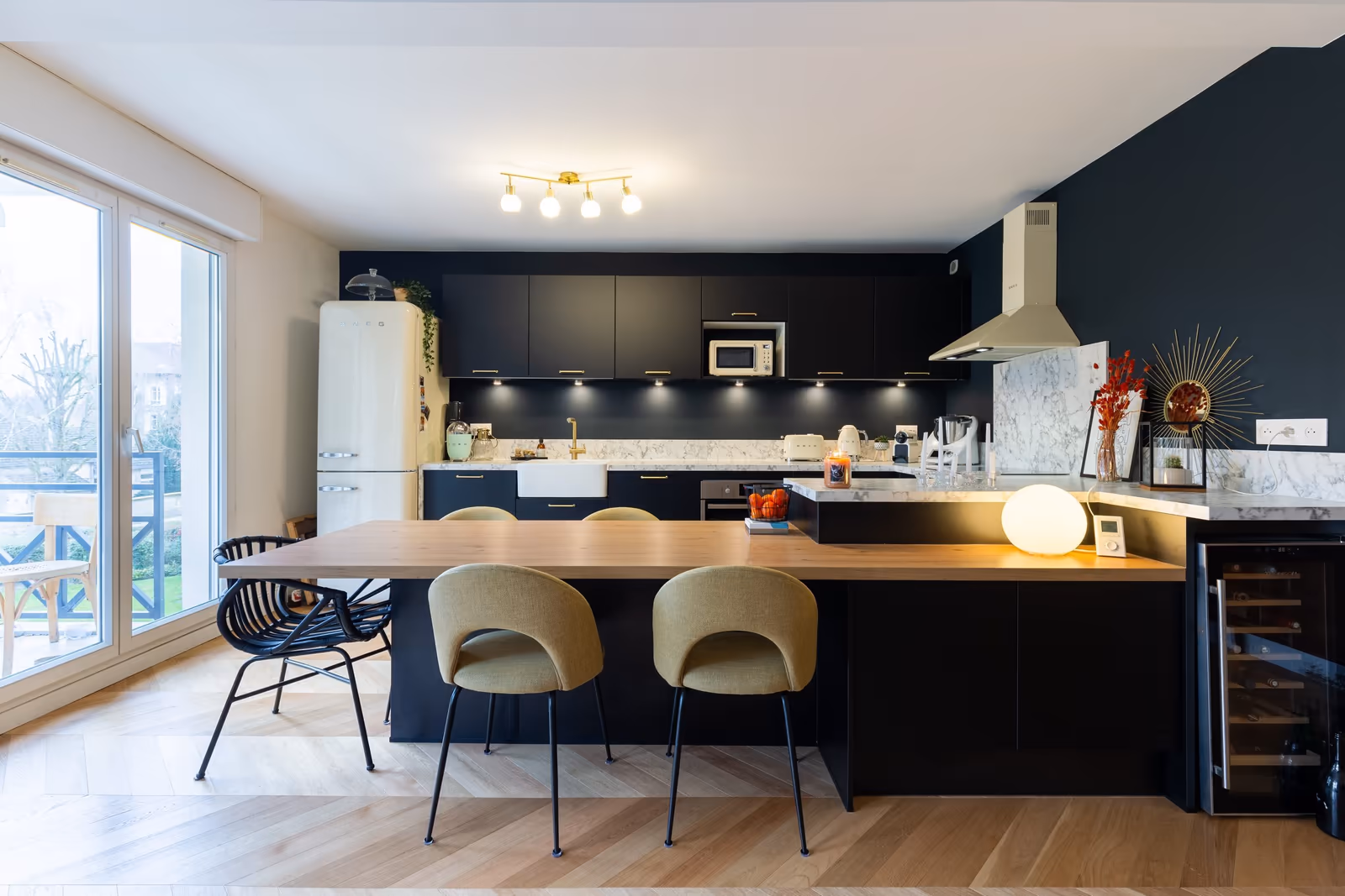 Cuisine marine avec armoires noires, îlot en bois et sol en bois clair
