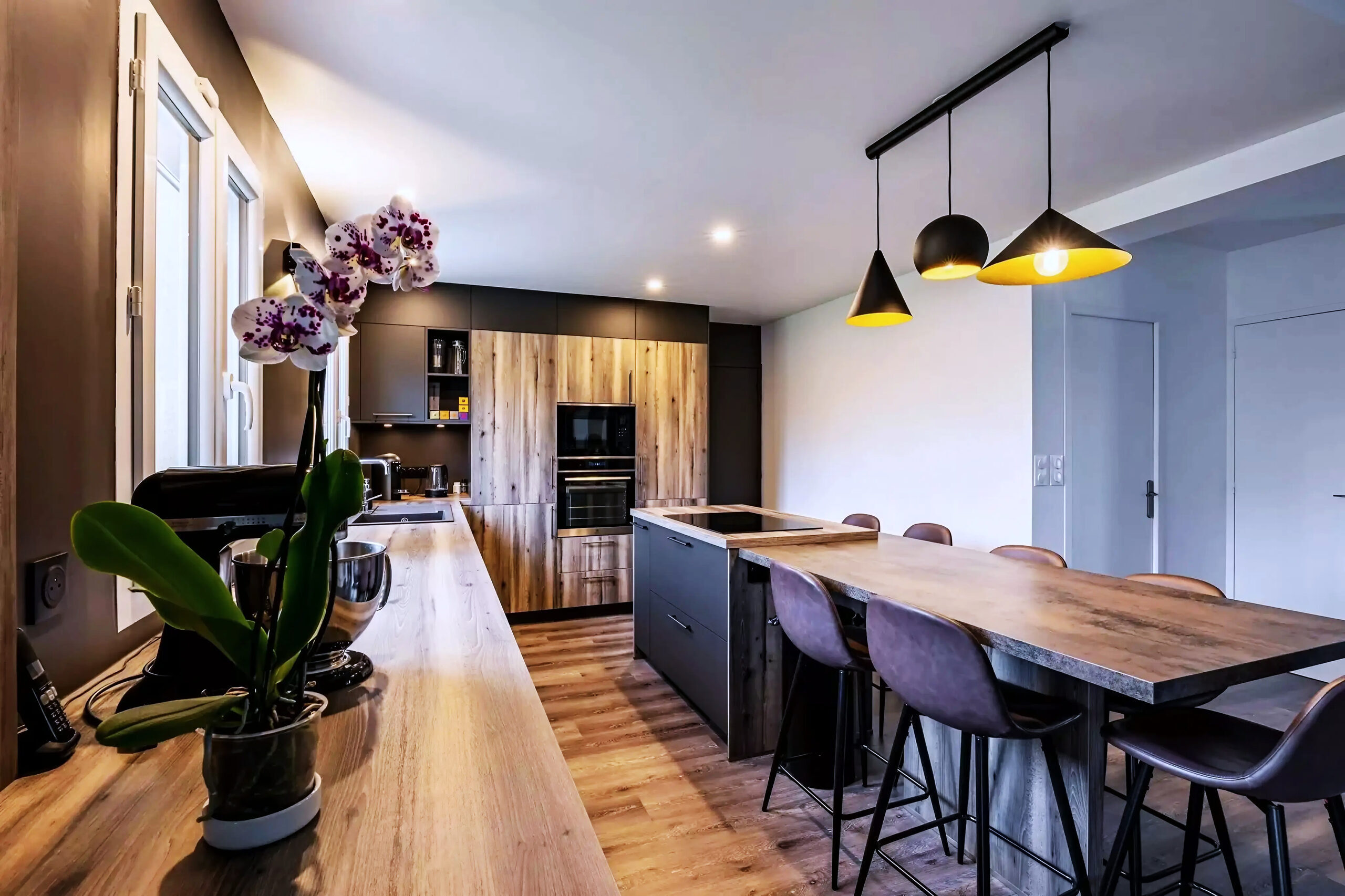 Cuisine nordique avec comptoirs en bois, îlot central et fours encastrés, réalisation Dec Home Agencement